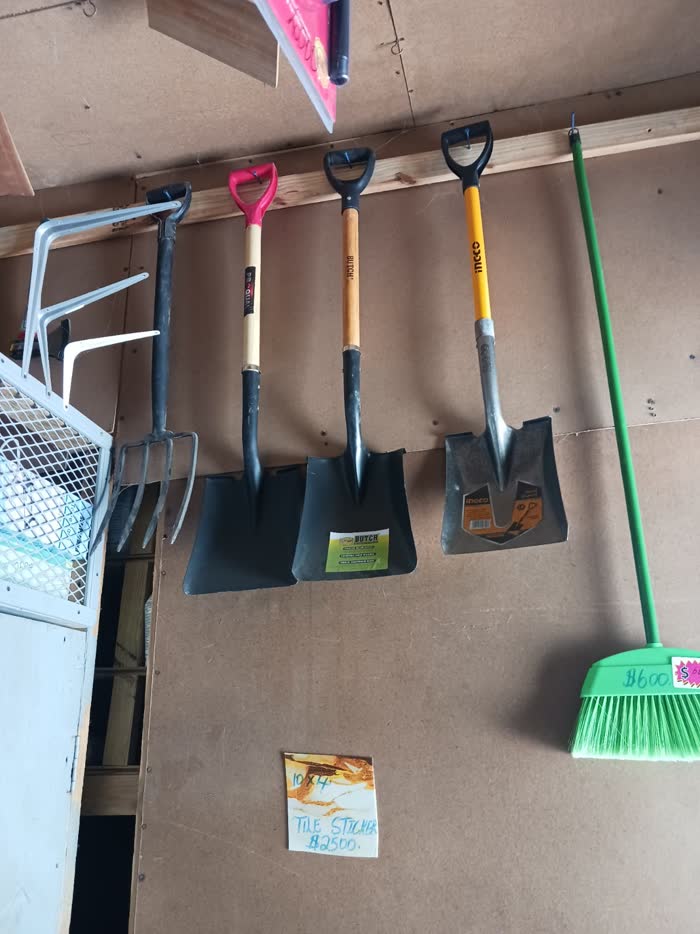 Shovels, forks and brooms on the tool wall